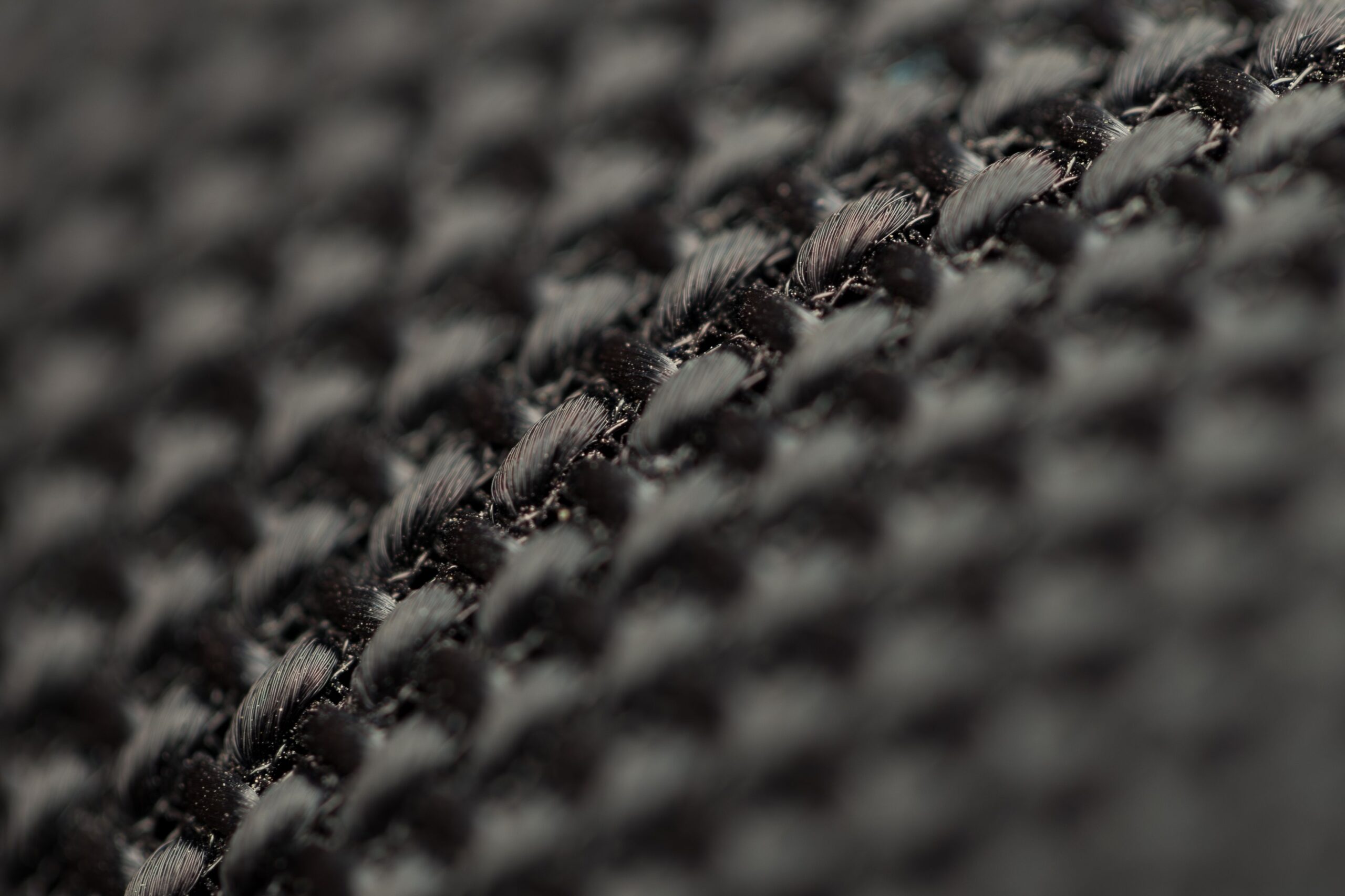 Black technical woven fabric texture, showing material construction details