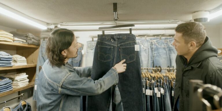 Two men inspecting a pair of vintage indigo jeans in a Japanese vintage denim shop