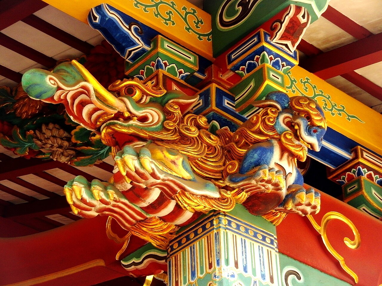 Brightly painted baku sculpture carved into the beams and pillar bracket of a Japanese shrine