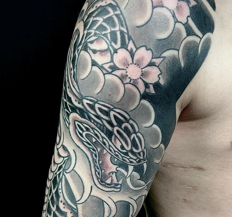 Black and grey Japanese snake tattoo with cherry blossom flowers on the arm