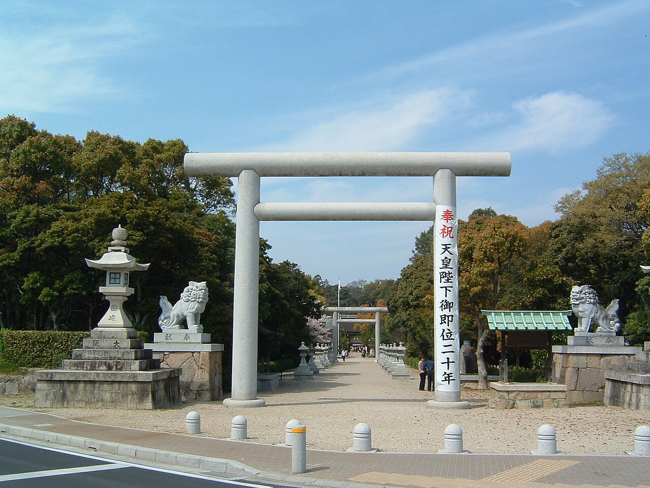 Stone torii gate and guardian lions on the approach to Izanagi Jingu shrine on Awaji island