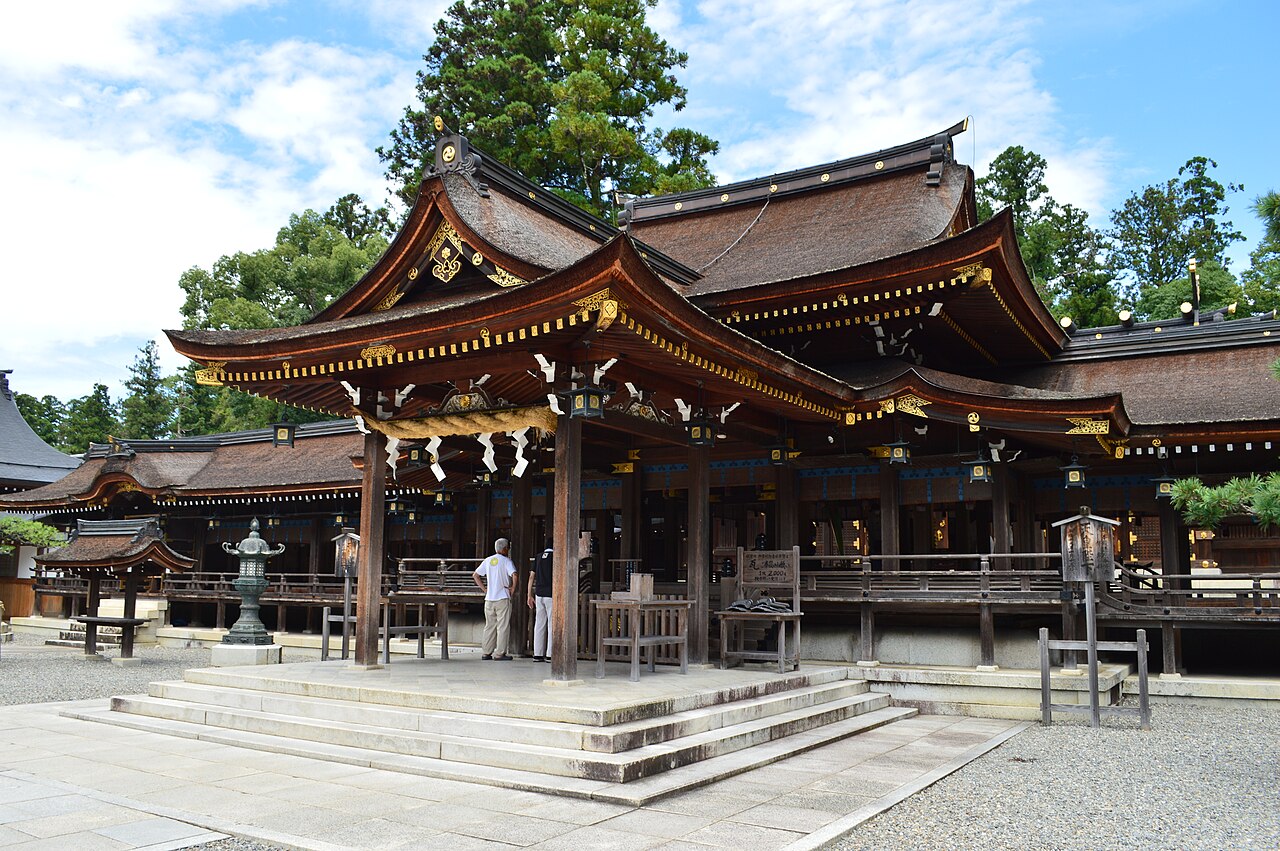 Wooden worship hall of Taga Taisha shrine with gold fittings and a hanging straw rope