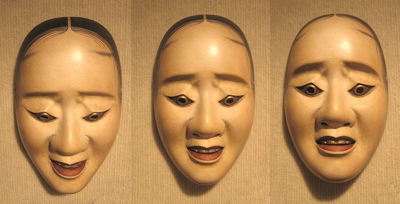 The same Noh mask photographed at three angles, its expression shifting from smiling to sorrowful