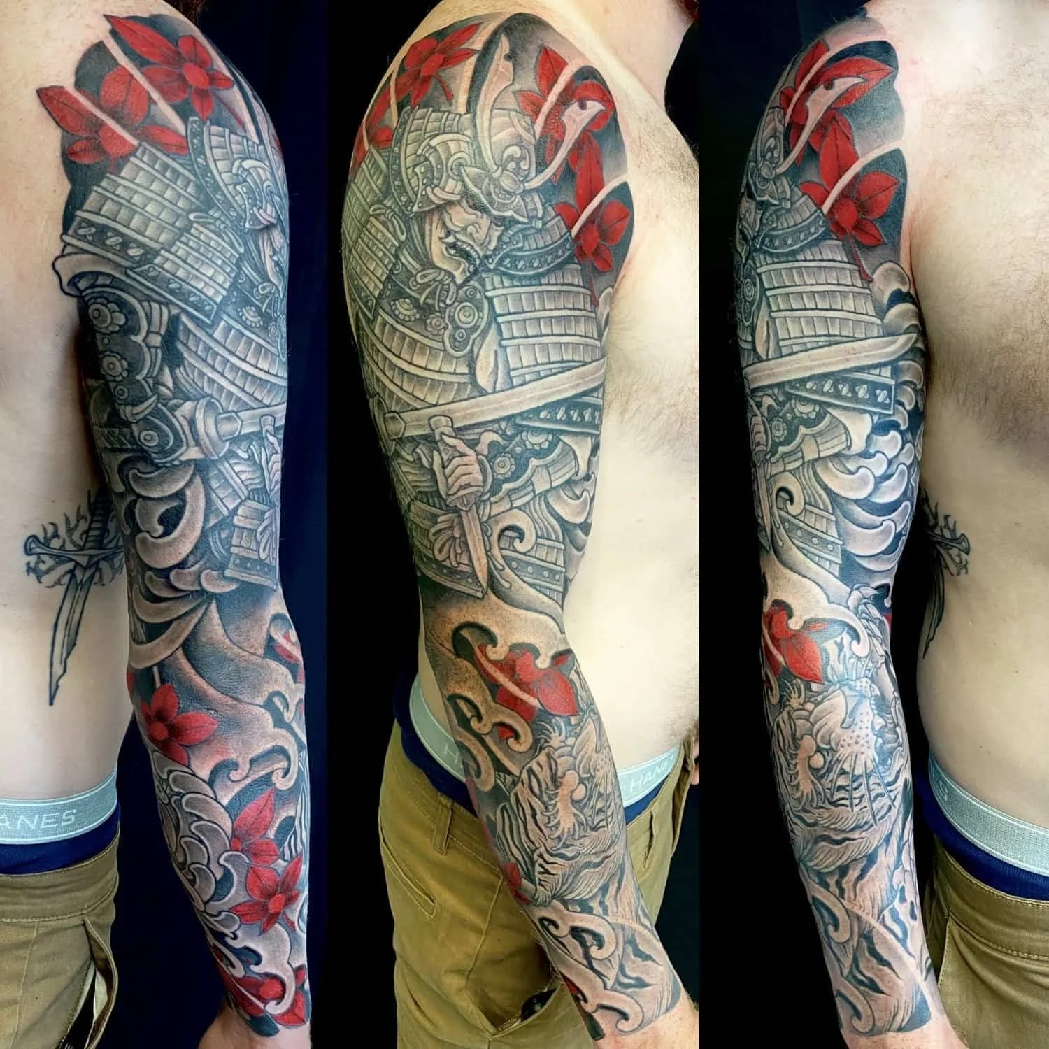 Full arm tattoo sleeve in grey wash showing a helmeted samurai with a drawn sword, red maple leaves and curling waves