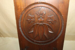 Wooden signboard carved with the Minamoto clan sasa rindo family crest inside a circle