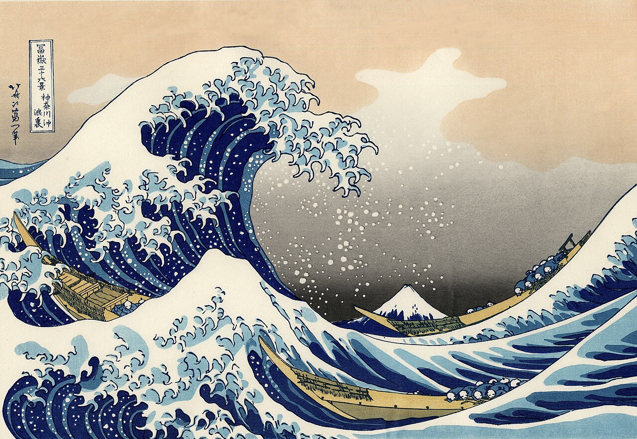 Hokusai woodblock print of a towering blue wave with clawed foam crests curling over three fishing boats, snow-capped Mount Fuji small in the distance