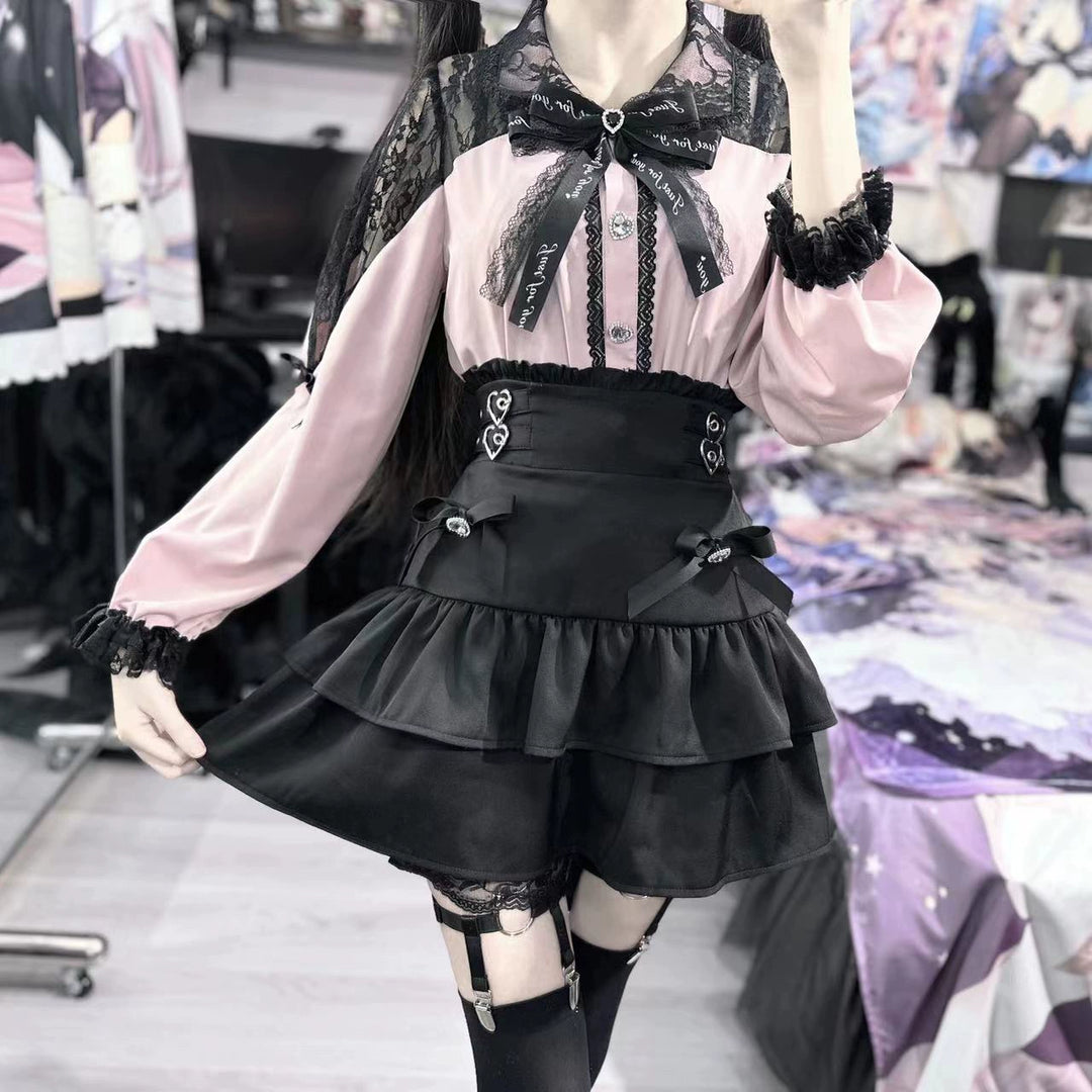 A jirai kei coordinate pairing a pink lace trimmed blouse with a black tiered ruffle skirt and black thigh highs