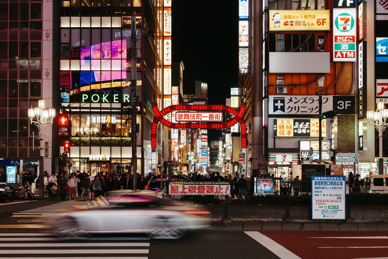 The red neon gate of Kabukicho Ichibangai in Shinjuku, Tokyo, crowded with people at night