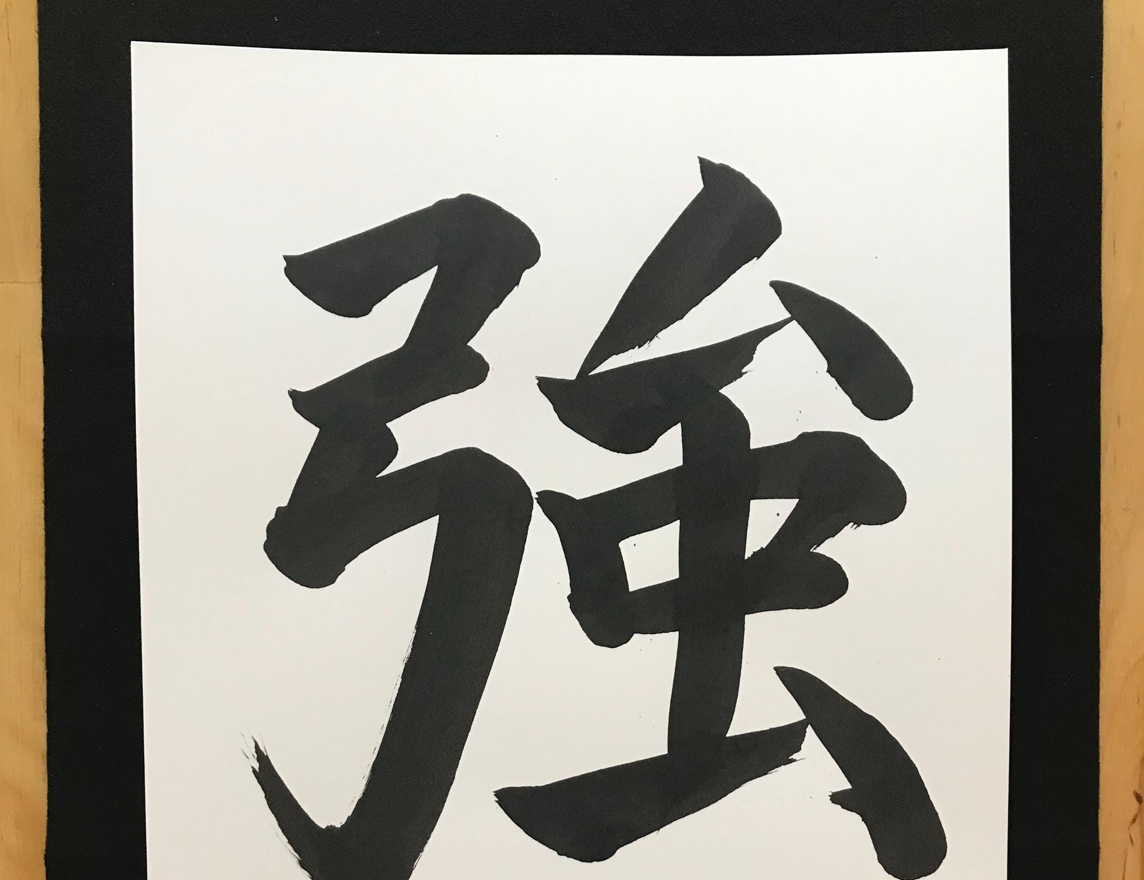 Brush calligraphy of the kanji 強, the Japanese symbol for strength