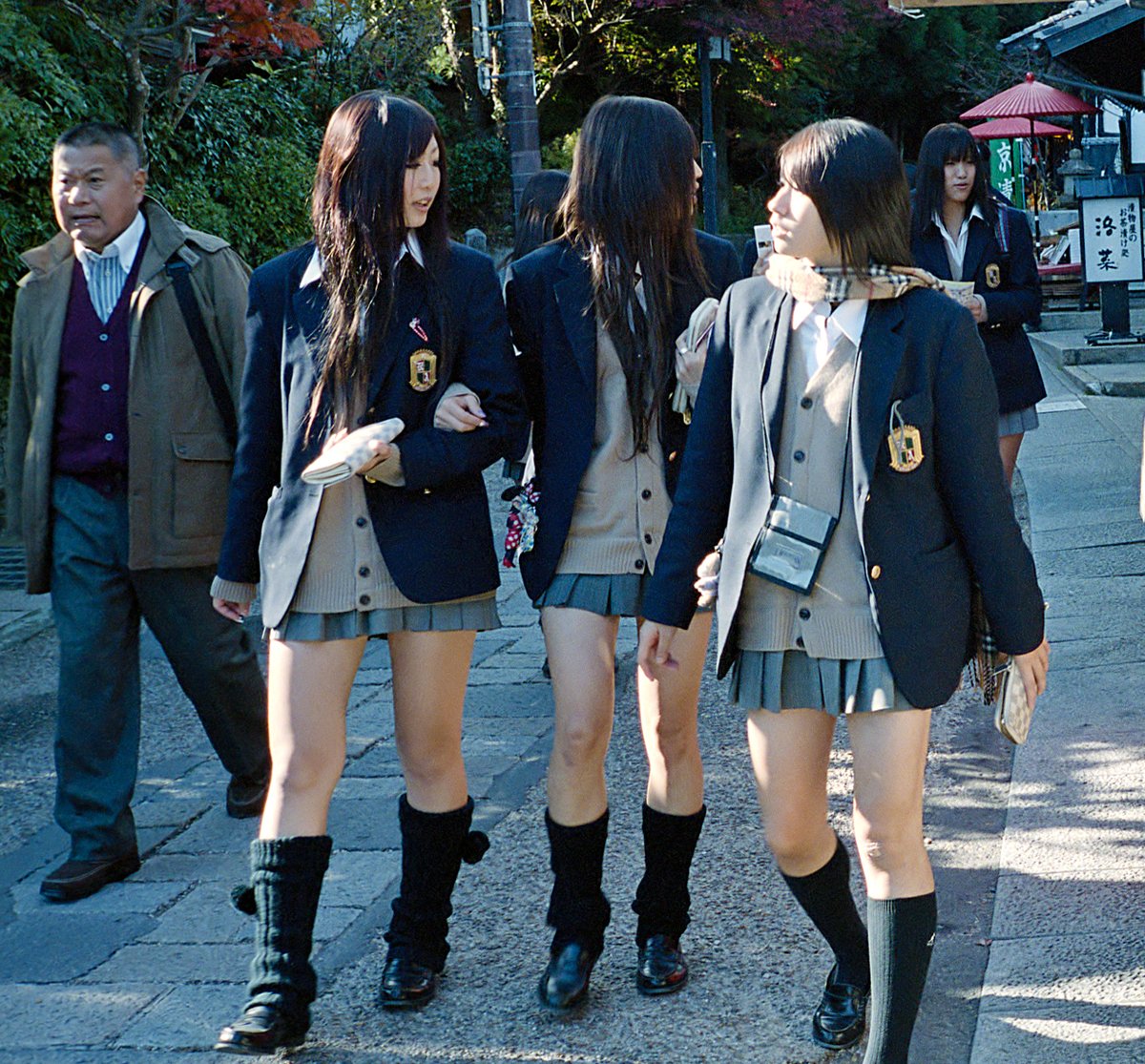 Japanese students in shortened pleated skirts wearing slouchy loose socks over loafers