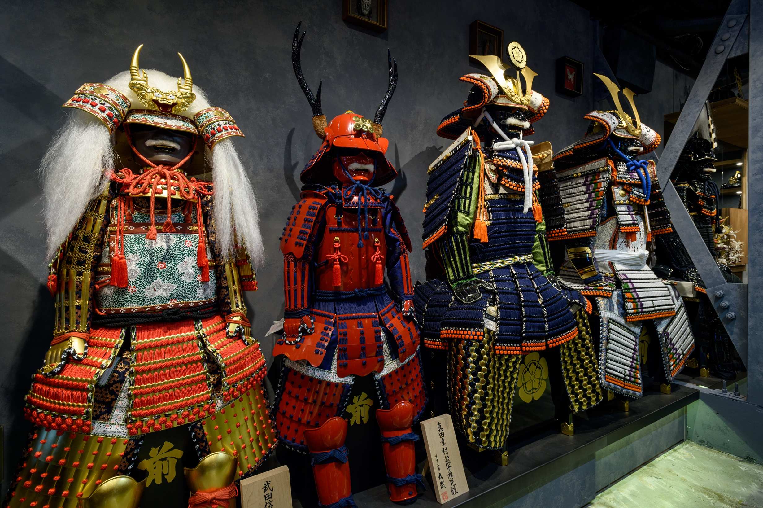 Full o-yoroi style samurai armor set displayed on a stand, showing the boxy cuirass and large shoulder guards