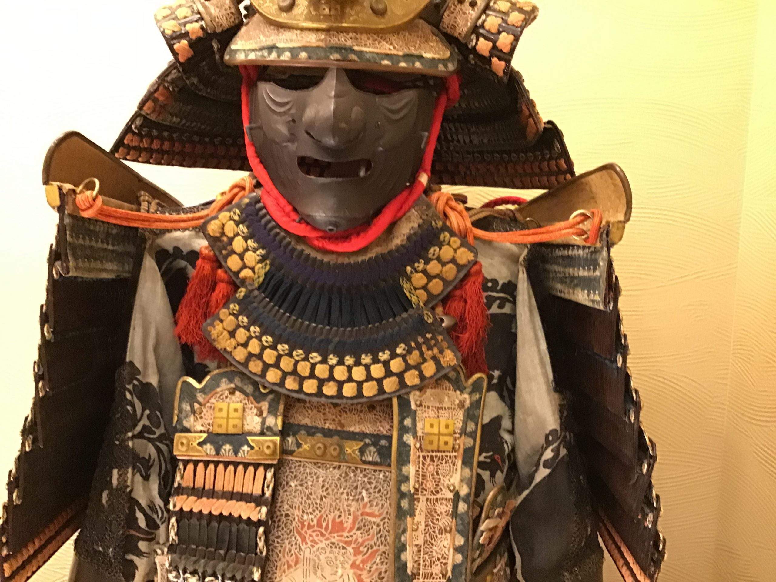 Front view of an o-yoroi samurai armor set on display, showing the tightly laced chest plates and shoulder guards