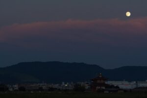 Full moon rising over the reconstructed Suzakumon gate of Heijo Palace in Nara at dusk