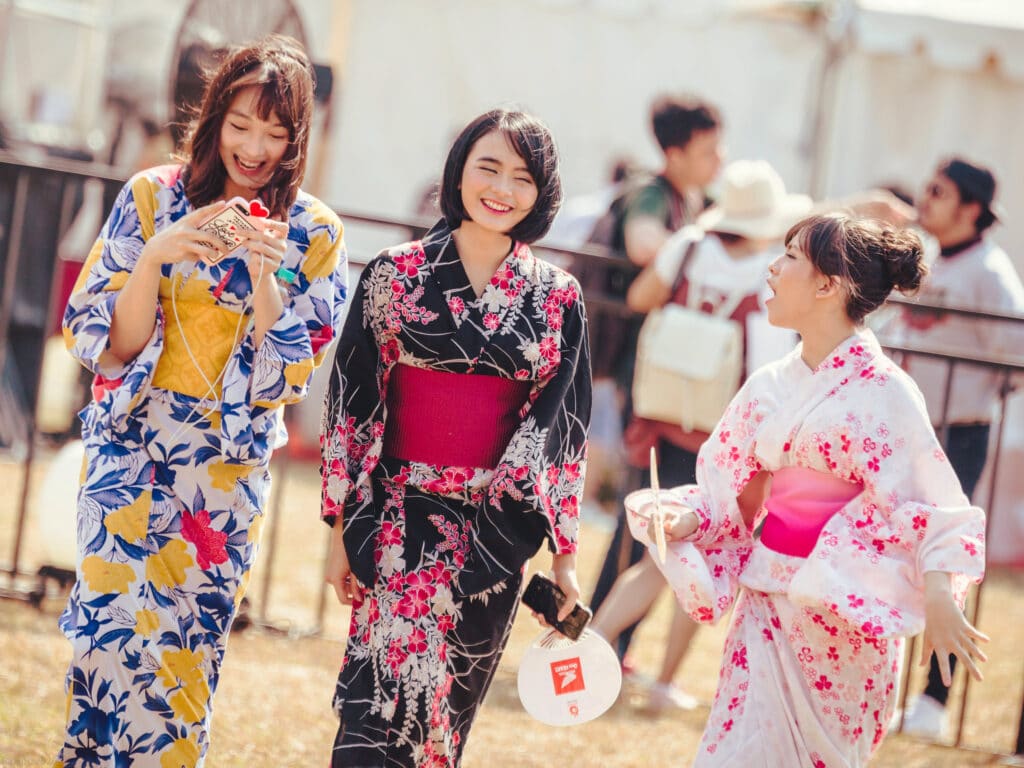 Two women adjusting their yukata and obi before heading out