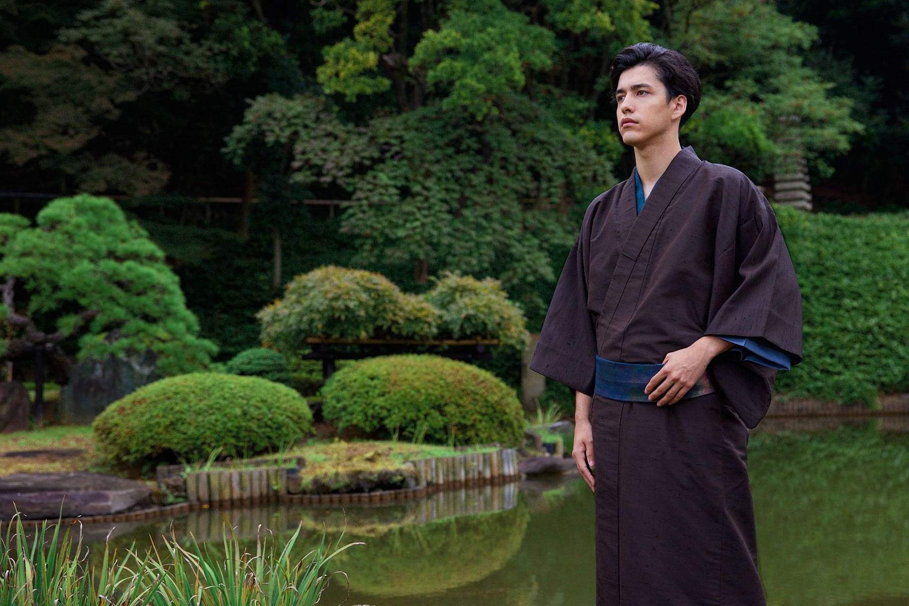 Man in a plain brown mens yukata with a narrow obi and a blue under layer showing at the collar