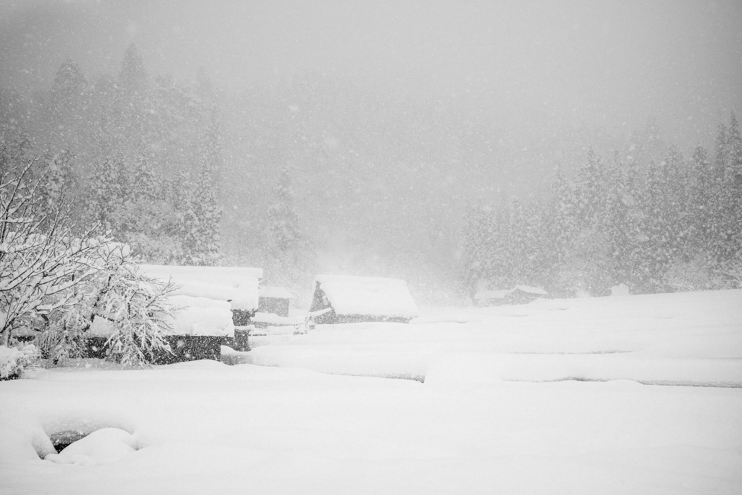 Thatched roof houses in a Japanese mountain village buried under heavy snow during a whiteout blizzard